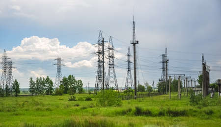 Electricity power lines in green field of grassの写真素材