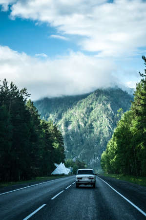 Old classic car on the road in mountainsの写真素材