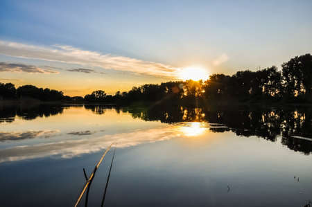 Fishing rod on the lake in sunset evening time. Nature Landscape.の写真素材