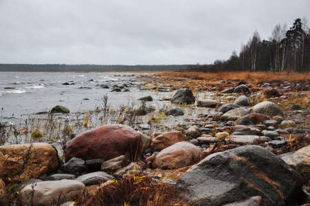 Stones on the shore of stormy waving Ladoga lake. Priozersk, Russia.