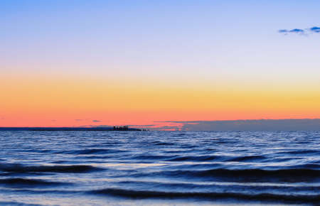 Dawn at the Ladoga. Waves and the small island on the lake in soft light of sunriseの写真素材