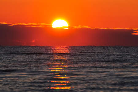 Dawn at the Ladoga. The sun rising above the lake reflecting in the waves.の写真素材