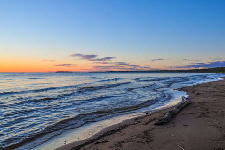 Waves on the shore of Ladoga lake at dawn. Beautiful sunrise landscapeの写真素材
