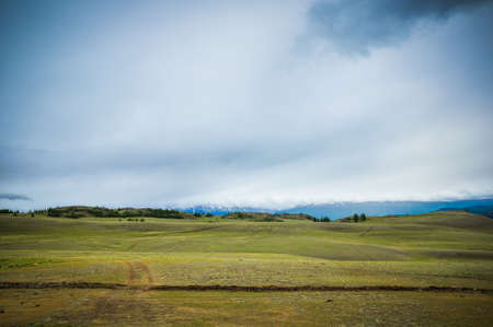 The road in the steppe surrounded by mountains. Altai, Russiaの写真素材
