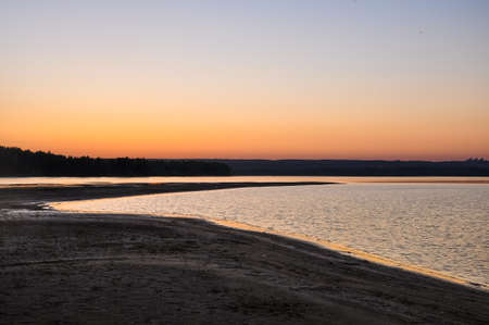 Tranquil nature scene. Sunset dawn sky above the sandy beach and water surface of the river Ob in soft evening colors. Altai, Russiaの写真素材