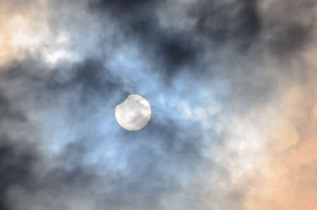 Partial Solar Eclipse in the Cloudy skyの写真素材