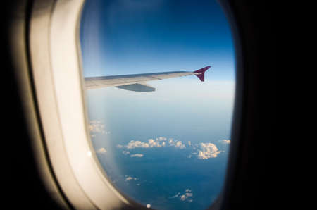 Airplane flying above clouds at sunrise. Aerial window view.の写真素材