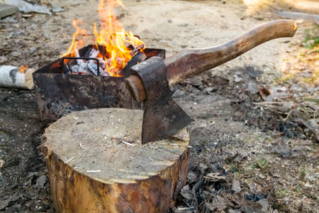 The axe in the log and wood against grill fire for cooking BBQ meat. Outdoor picnicの写真素材