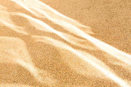 Light reflections create sand dunes effect on a roadの写真素材