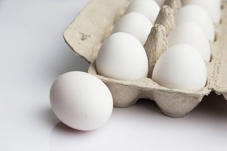white chicken eggs on a white backgroundの写真素材