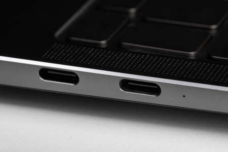 fragments and buttons of a black and silver laptop with white letters