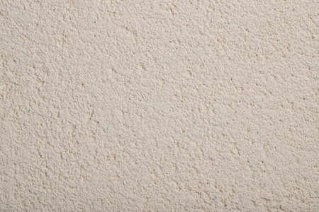 beige textured plaster on the wall of the house, background