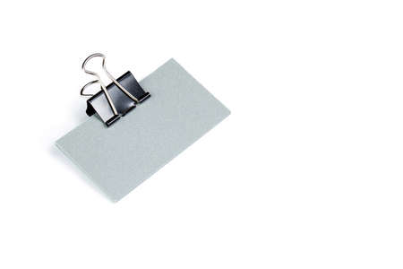 pack of paper blanks for business cards with a metal clip on a light background, isolate
