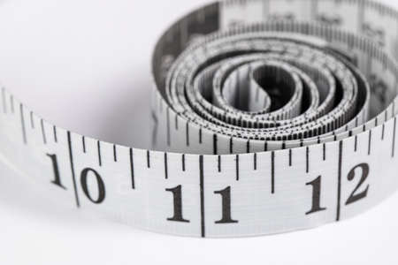 centimeter measuring tape with inches rolled up on a white background, isolateの写真素材