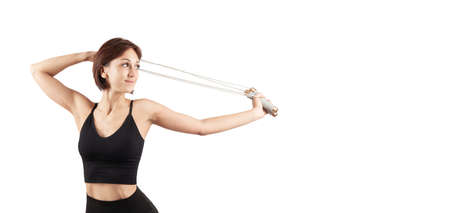 young beautiful woman in black leggings and top doing sports and yoga indoors, on a white...