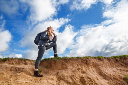 tourist girl with a camera walks along the river Bank on a Sunny day, autumnの写真素材