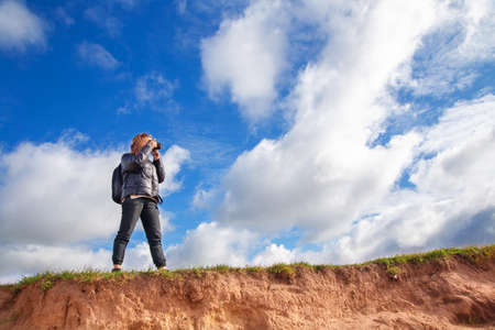 tourist girl with a camera walks along the river Bank on a Sunny day, autumn