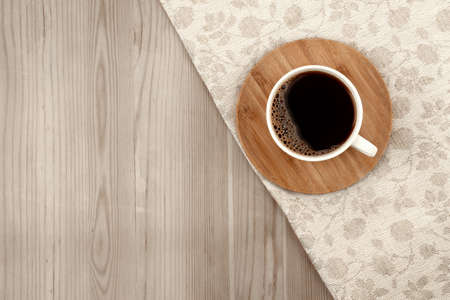 white coffee Cup on wooden background with gray linen tablecloth in jacquard weave, space for textの写真素材