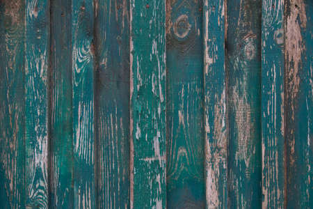 old wooden fence made of boards with peeling paint and scratches, background, grungeの写真素材