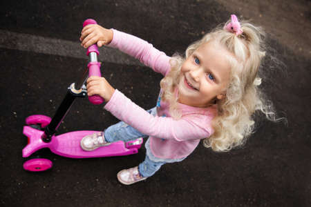 little girl with curly blonde hair on a walk, summer day