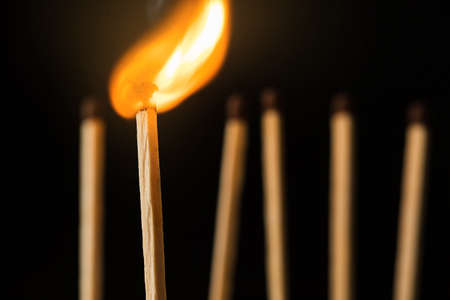 wooden lighted matches, standing on a black backgroundの写真素材
