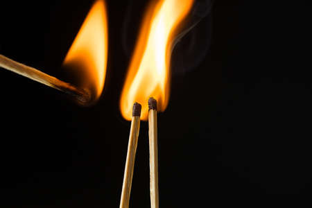 wooden lighted matches, standing on a black background