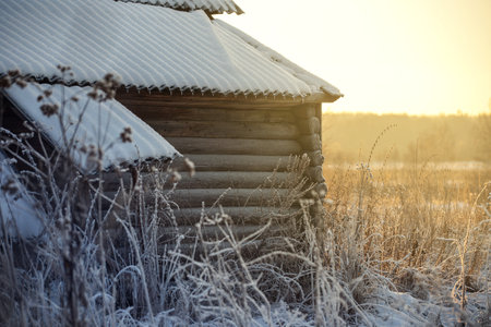 old log house in the village, winter evening, sunsetの写真素材