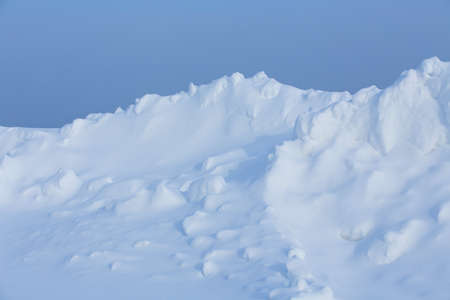 winter landscape, snow-covered field with snowdrifts against the blue skyの写真素材