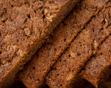 sliced rye bread with cumin, lying on a wooden board