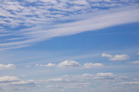 blue sky with white clouds of various shapes, sunny day, textureの写真素材