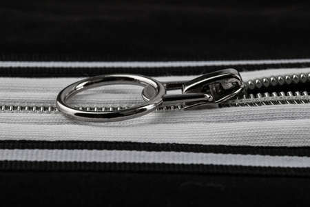 a fragment of a sewing product, polyester clothing, double seam, zipper made of white metal
