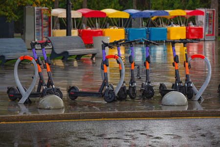 electric scooter rental parking in the building of the river station, Moscow, autumn rainの写真素材