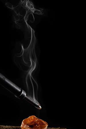wax candle with burning wick and smoke, isolated on a black backgroundの写真素材
