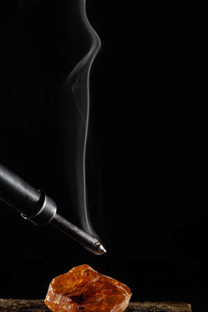 wax candle with burning wick and smoke, isolated on a black backgroundの写真素材