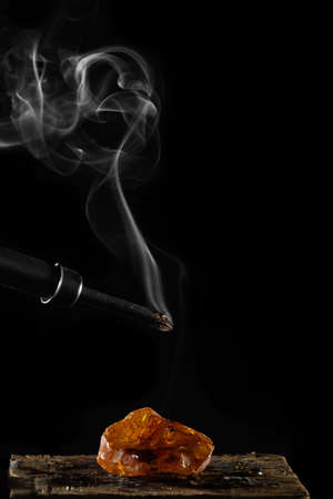 wax candle with burning wick and smoke, isolated on a black backgroundの写真素材