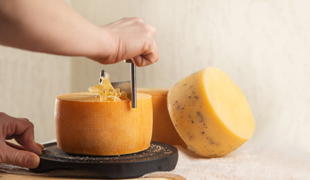 cheese of different varieties on a natural wooden background, whole and cutの写真素材