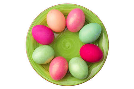 green clay plate with multicolored easter boiled eggs isolated on a white backgroundの写真素材