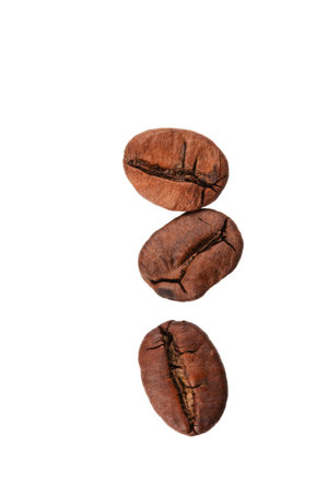 roasted whole arabica coffee beans, scattered on paper, isolatedの写真素材