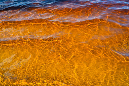 the water surface of a river or lake with sun glare at sunsetの写真素材