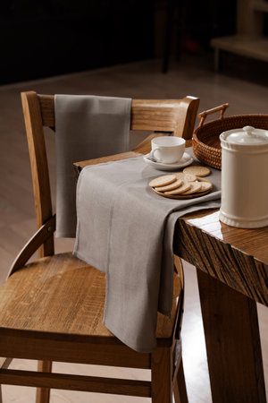 gray cotton towels and napkins on a wooden table and on the back of a chair, kitchen, dining roomの写真素材