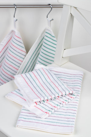 multi-colored striped terry towels for the kitchen with a loop for hanging on a hook, isolatedの写真素材