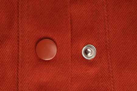 type of fastener on a slotted loop, processed by machine seam and a button covered with the main...