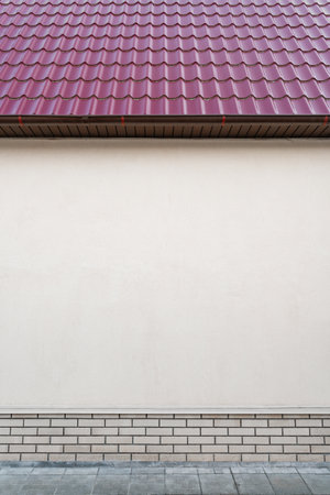 the wall of a brick house with a roof and skylights, construction industry