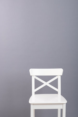 white wooden chair on a gray wall backgroundの写真素材