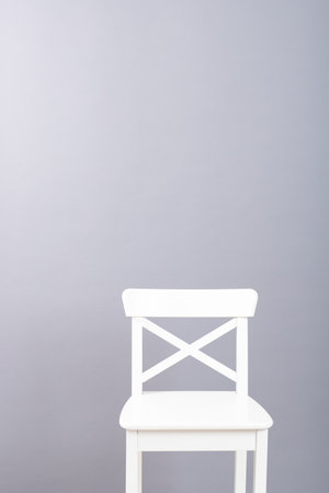 white wooden chair on a gray wall backgroundの写真素材