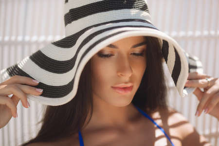 Beautiful girl in the stripped hat on the beachの写真素材