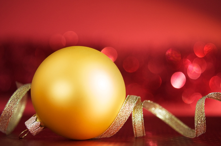 Golden xmas ball and ribbon on the redの写真素材