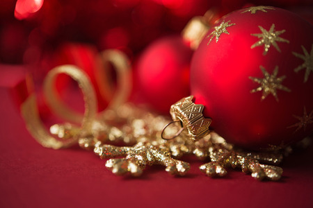 Red and golden christmas ornaments on red xmas backgroundの写真素材
