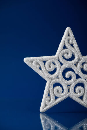 White xmas star on dark blue christmas background with space for text.の写真素材