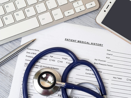 Stethoscope lying on patient medical history form. Therapist working table. Healthcare and medical conceptの写真素材